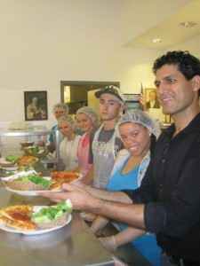 Kadwani serving pizza at pizza party