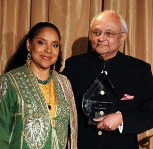 Ajit Hutheesing (left) accepts the Giving Back Award for Nimesh Kampani from emcee Phylicia Rashad
