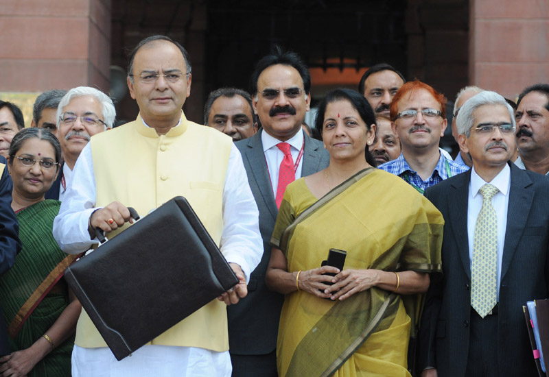 In this file photo, dated July 20, 2014, India’s Minister for Finance Arun Jaitley is seen departing from North Block to Parliament House, along with Minister of State for Commerce and Industry Nirmala Sitharaman, to present the General Budget 2014-15. (Photo credit: Press Information Bureau).