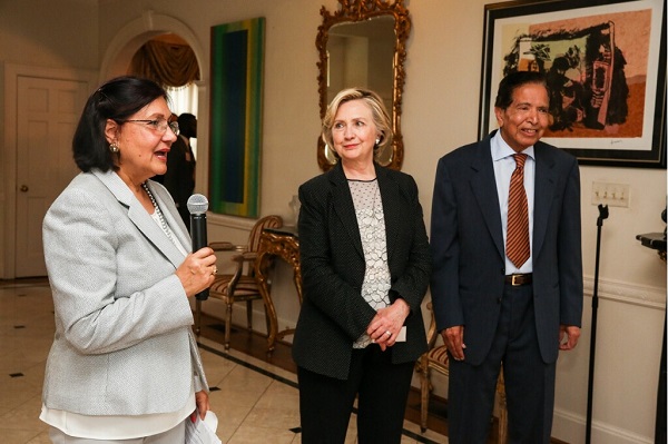Mahinder Tak speaks at a fundraising event held at her residence in Potomac, MD, for Hillary Clinton, on July 1, 2015, as the former secretary of state looks on. Also seen in the photo is Sharad Tak.