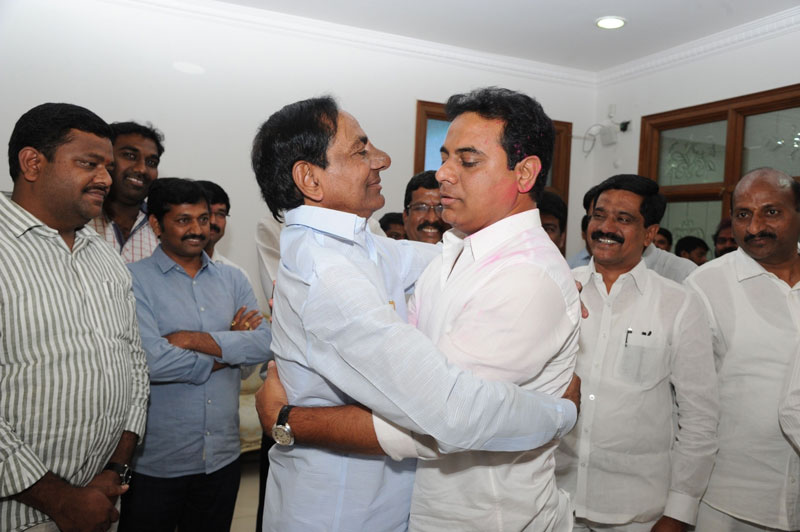 Telangana Chief Minister and TRS leader K Chandrasekhar Rao greets Telangana IT minister and his son K T Rama Rao after winning the Greater Hyderabad Municipal Corporation (GHMC) polls in Hyderabad on Feb 5, 2016. (Photo: IANS)
