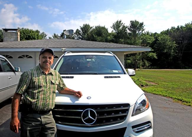 Surjeet Bassi stands next to his Mercedes-Benz (Image Courtesy: ELAINE A. RUXTON/TIMES HERALD-RECORD / twitter)