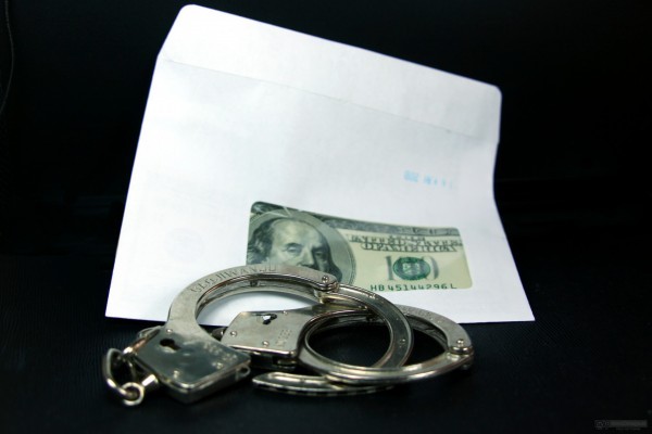 Fraud. Dollars, handcuffs.