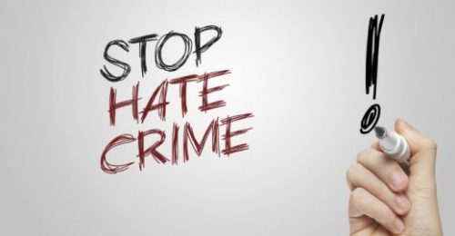 Hand writing stop hate crime on grey background