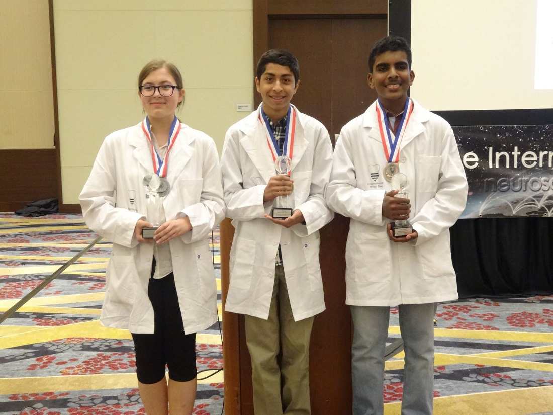 Indian American whiz kid Sojas Wagle (center) is the 2017 World Brain Bee Champion. At left is Milena Malcharek of Poland, in second place, and at right is Elwin Vethamuthu of Malaysia who finished third in the neuroscience competition for teenagers.