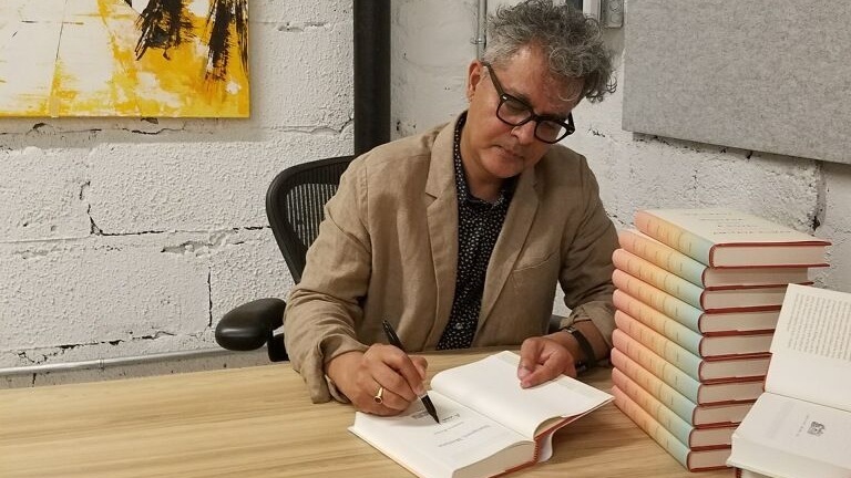 Amitava Kumar signing copies of his book "Immigrant, Montana" at Politics and Prose in Washington, DC, on August 10, 2018