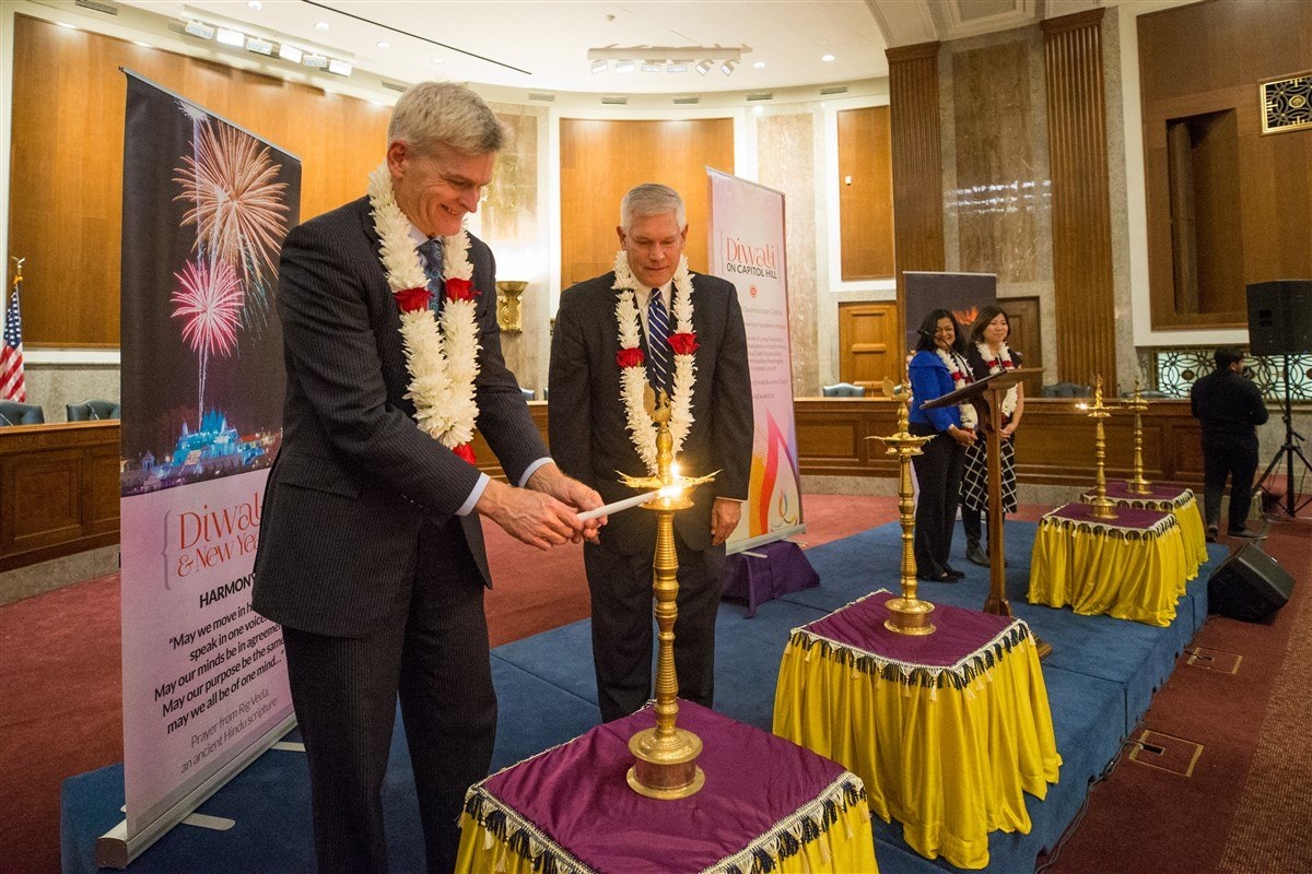 Sen. Bill Cassidy lights the 'diya' (lamp) at the 2018 Diwali celebration on Capitol Hill. Looking on, from left to right, are: Congressman Pete Sessions; and Congresswomen Pramila Jayapal and Grace Meng. Photo credit: BAPS 