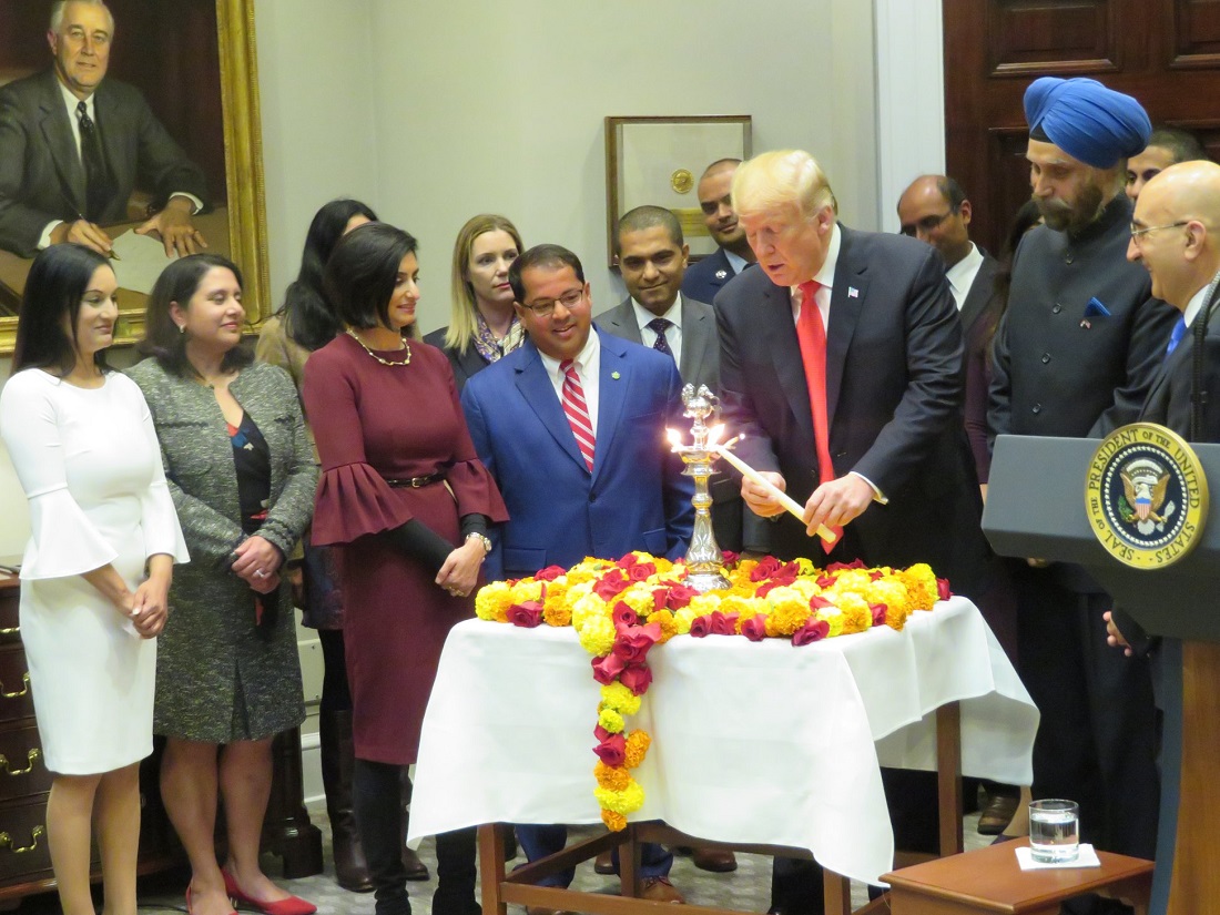 President Trump lights the Diwali 'diya' (lamp) at the White House, surrounded by Indian Americans serving in his administration and high-ranking Indian officials. Seen second from right is Indian Ambassador to the United States Navtej Sarna.
