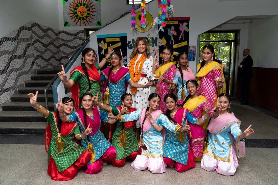 First Lady Melania Trump is flanked by exuberant students who danced to Bhangra beats during her visit to the Sarvodaya Co-Educational Senior Secondary School in New Delhi. Official White House Photo by Andrea Hanks