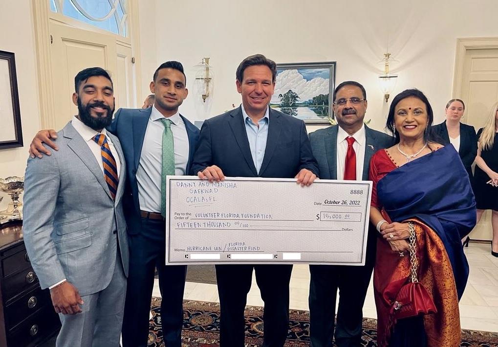 Gov. Ron DeSantis with a check presented by entrepreneur Ocala, FL, Danny Gaekwad and his wife, Manisha, for the Florida Disaster Fund during a Diwali event hosted by the governor at his official mansion. Also seen are the two children of the couple, Kunal and Karan.